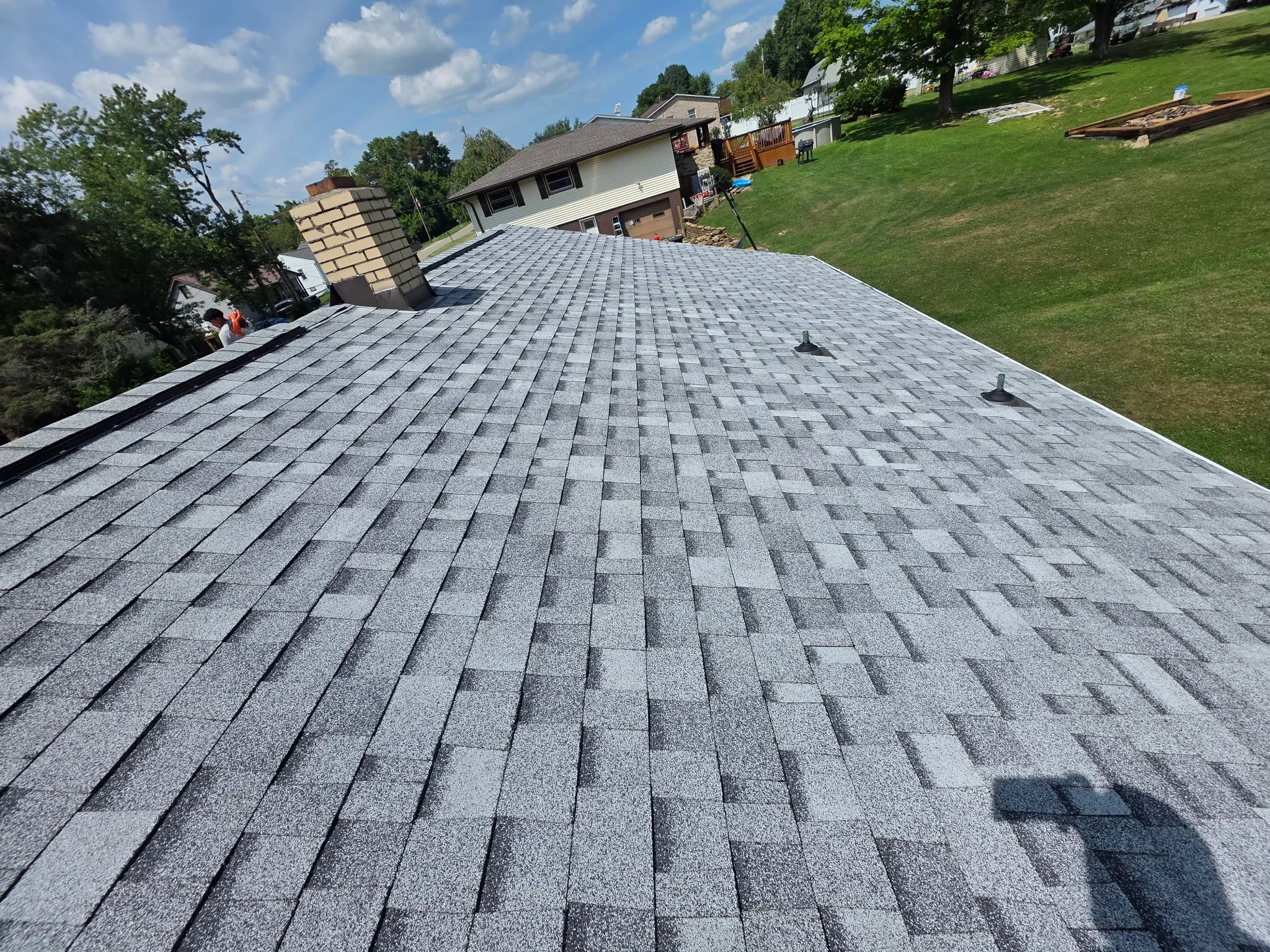 New gray architectural asphalt shingle roof with dimensional pattern and roof vents installed