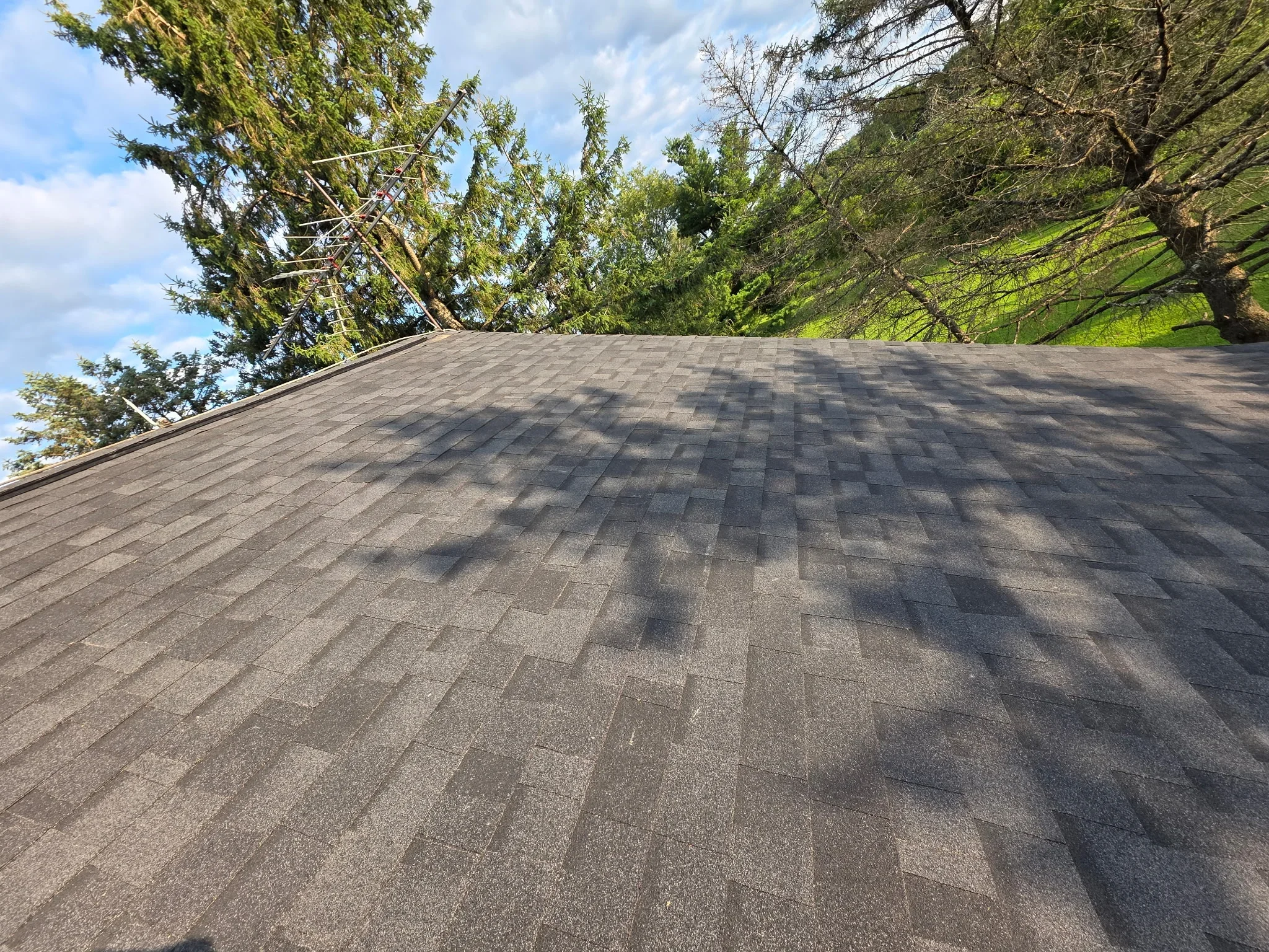 Gray architectural shingles installed in staggered pattern on sloped residential roof