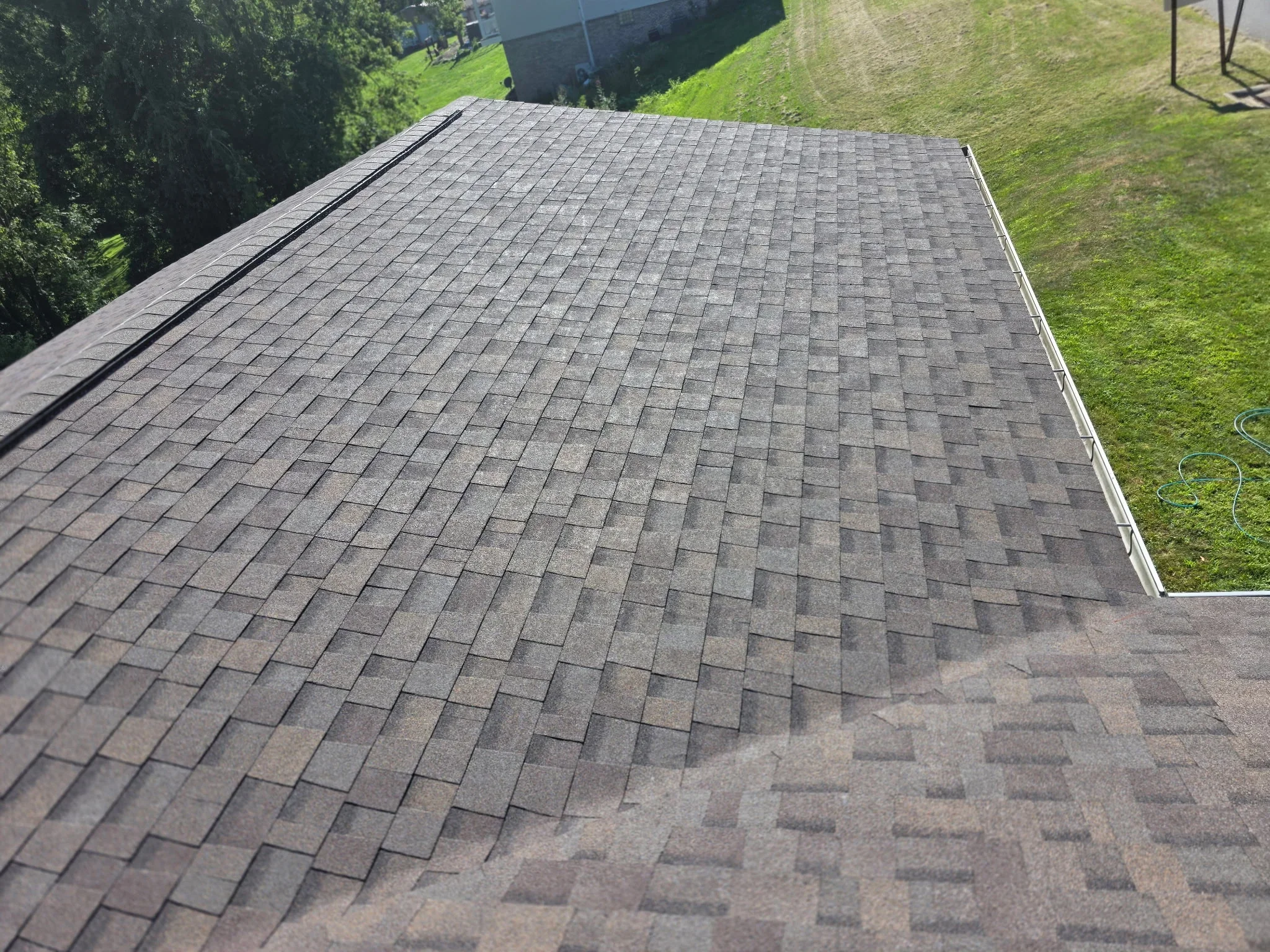 Newly installed gray architectural asphalt shingles with dimensional pattern and clean edge details
