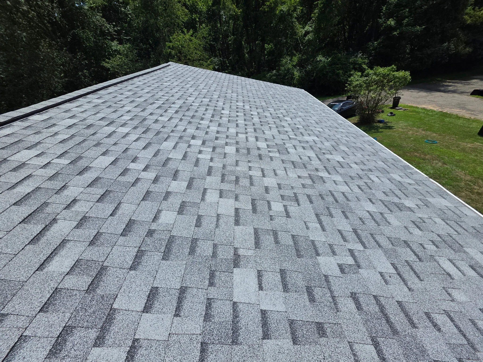 Gray architectural asphalt shingles installed in staggered pattern on pitched roof