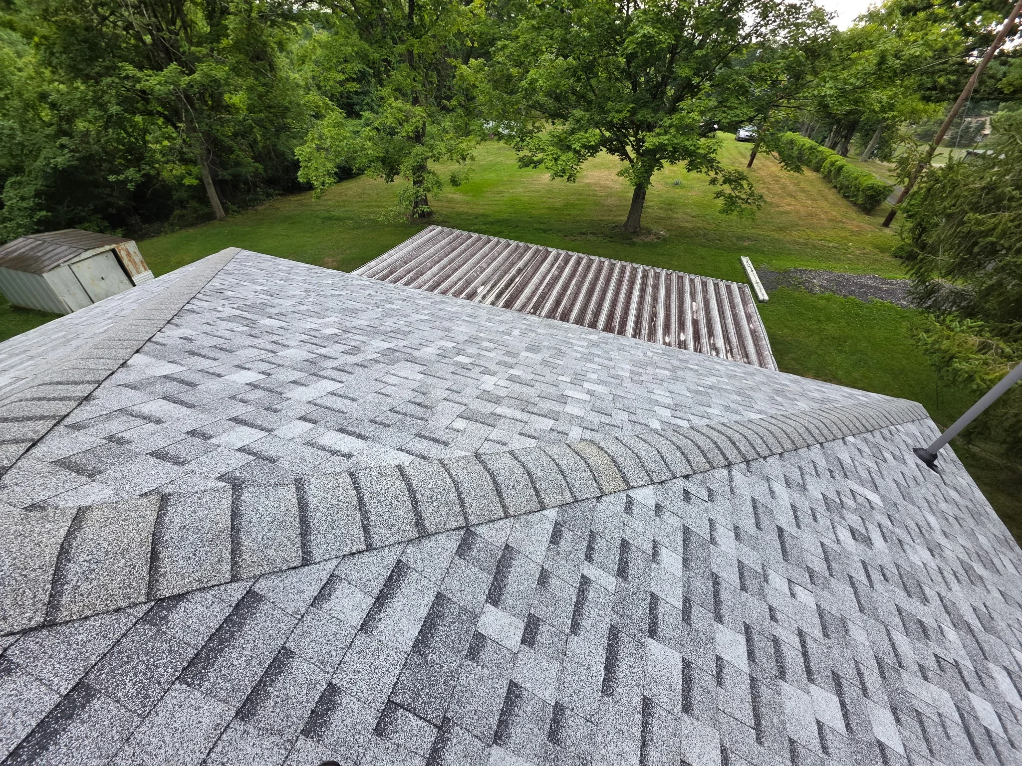 Gray architectural shingles installed on pitched roof with dimensional pattern and proper overlap
